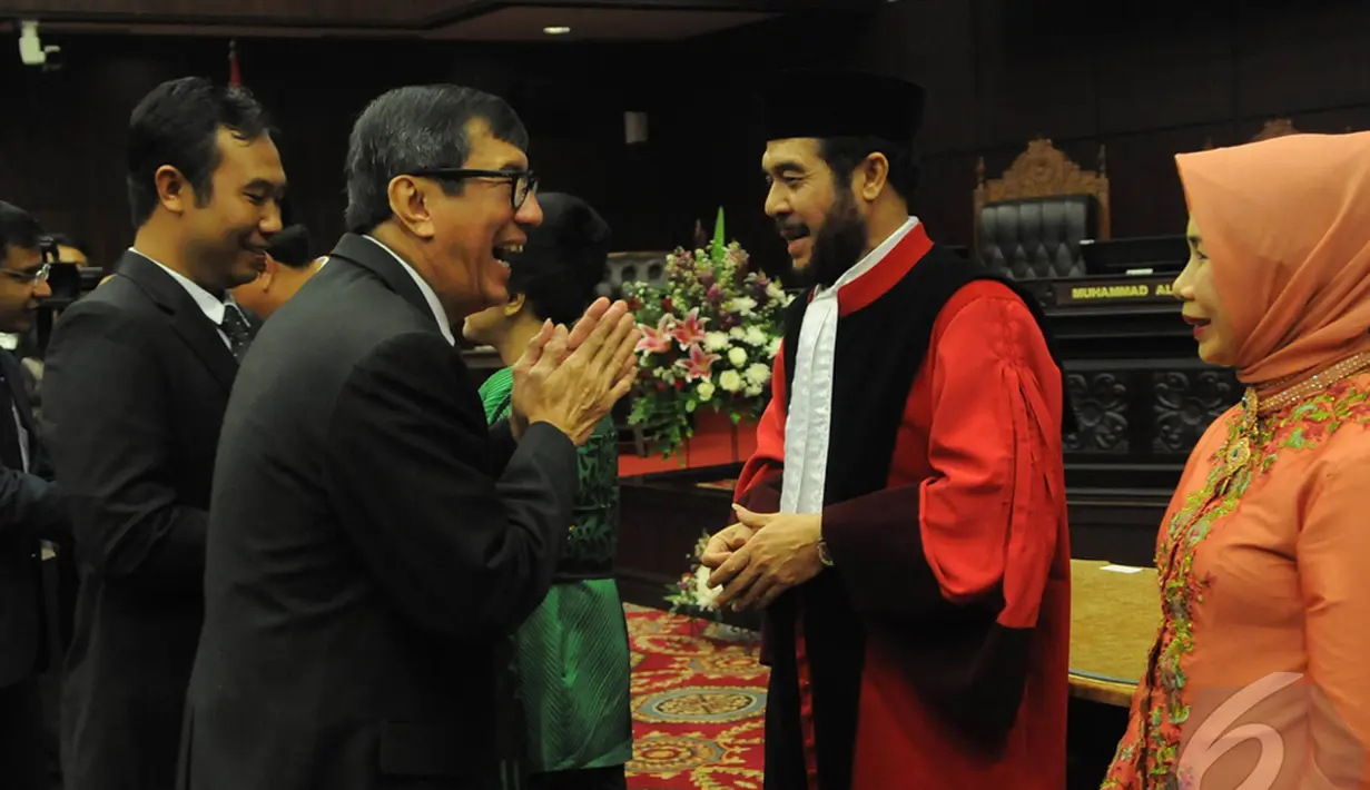 Menteri Hukum dan Ham (Menkumham) Yasonna Laoly memberikan selamat kepada Wakil Ketua MK yang baru, Anwar Usman, di Gedung Mahkamah Konstitusi, Jakarta, Selasa (14/1/2015). (Liputan6.com/Herman Zakharia)