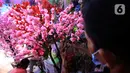 Pedagang saat membuat pohon bunga Meihua di salah satu toko Asemka, Glodok, Jakarta, Rabu (3/2/2021). Namun dimasa pandemi, penjualan bunga ini berkurang dikarenakan banyak pembeli yang lebih memilih pembelian online. (Liputan6.com/Johan Tallo)
