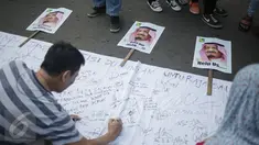 Pengunjung Car Free Day (CFD) menandatangani spanduk berisi petisi mendukung kedatangan Raja Salman, di Bundaran HI, Jakarta, Minggu (26/2). Petisi berisi harapan atas  kunjungan Raja Arab Saudi, Salman bin Abdulazis Al Saud. (Liputan6.com/Faizal Fanani)