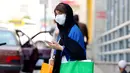 Seorang wanita Iran yang mengenakan masker menunggu untuk menyeberang jalan di ibu kota Teheran, Sabtu (3/7/2021). Presiden Hassan Rouhani mengaku khawatir Iran akan dilanda gelombang kelima pandemi Covid-19 karena kemunculan virus corona varian Delta. (ATTA KENARE/AFP)