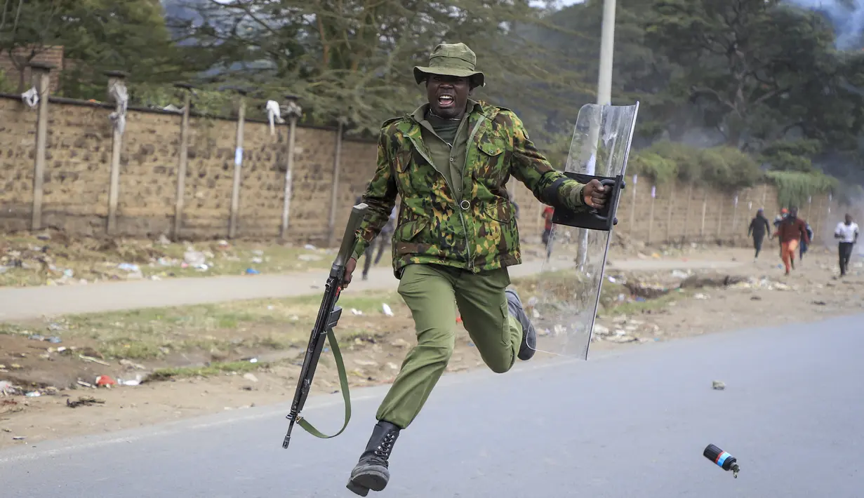 Seorang polisi melompat ketika dia berusaha menghindari granat gas air mata yang dilemparkan kembali ke arah polisi oleh pengunjuk rasa di lingkungan Mathare di Nairobi, Kenya Rabu, 12 Juli 2023. (AP Photo)