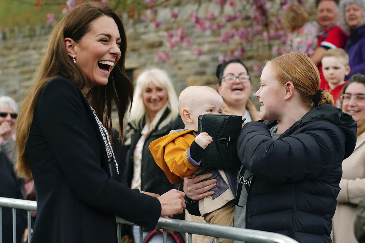 Kate Middleton ngakak lihat tasnya jadi mainan bayi umur setahun. (Ben Birchall/Pool via AP)