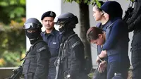 Terdakwa warga Indonesia, Siti Aisyah dikawal oleh polisi masuk ke Gedung Mahkamah Sepang, Selangor, Kamis (13/4). Sidang kedua kasus pembunuhan saudara pemimpin Korea Utara, Kim Jong-nam di bawah penjagaan ketat aparat keamanan. (MOHD RASFAN/AFP)