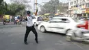 Polisi lalu lintas India Ranjeet Singh mengarahkan lalu lintas di persimpangan Indore, India (22/12). Saat mengatur lalu lintas, Ranjeet Singh menari moonwalk ala Michael Jackson yang menjadi perhatian warga sekitar.  (AFP Photo/Indranil Mukherjee)
