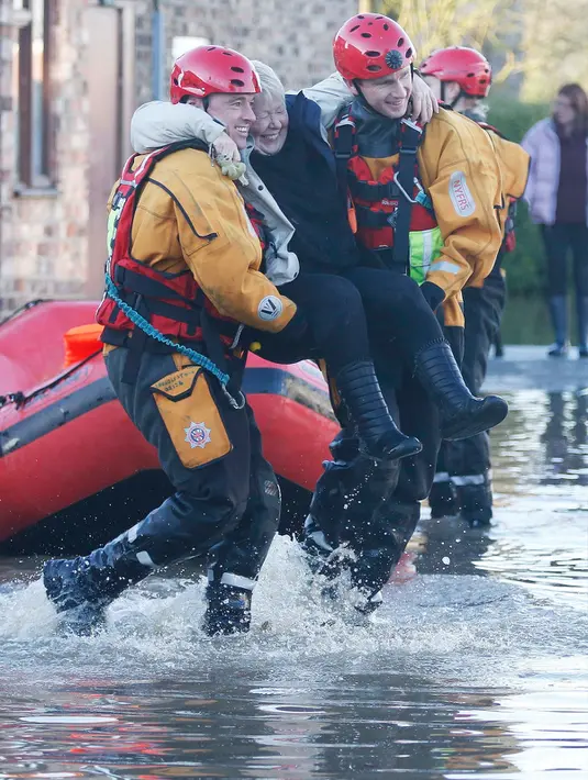 Petugas mengevakuasi warga yang terjebak banjir dirumahnya di York, Inggris utara, Minggu (27/12). Banjir akibat luapan sungai Ouse yang telah memperburuk sejumlah wilayah Inggris utara. (REUTERS/Phil Noble)