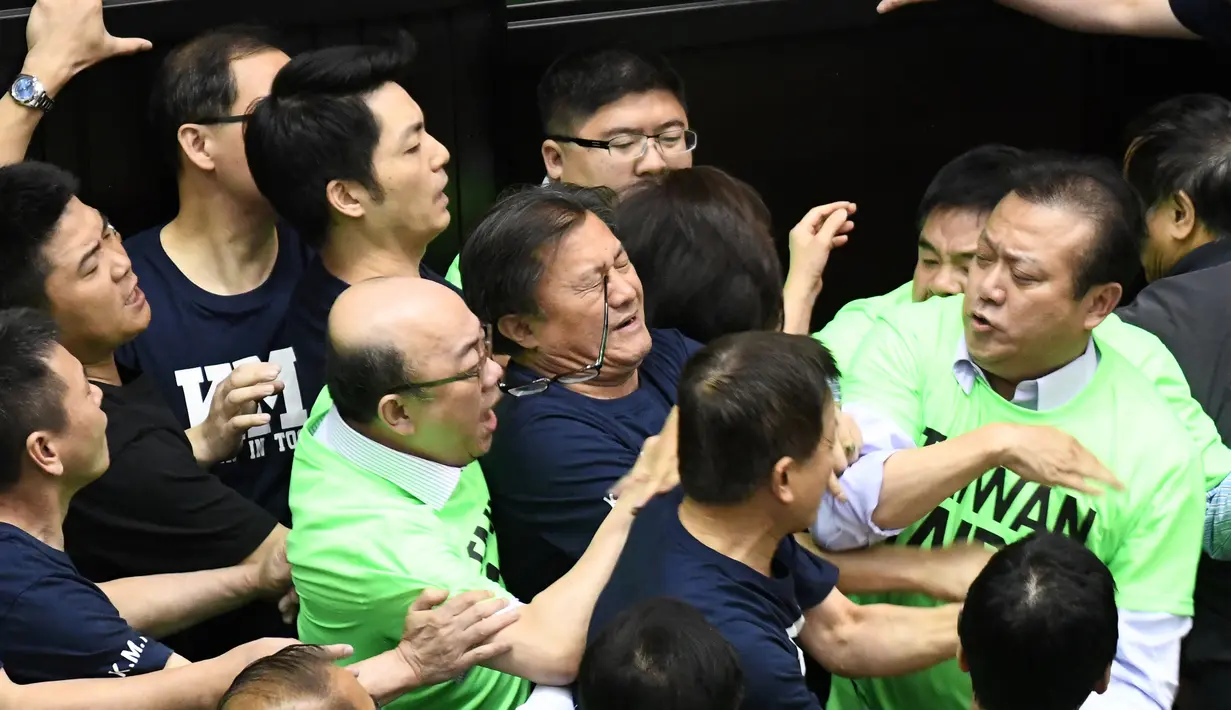 Anggota parlemen dari Partai Progresif Demokratik (DPP) berkelahi dengan Partai Nasionalis Tiongkok atau yang dikenal dengan Kuomintang (KMT) saat melakukan protes di Parlemen di Taipei (20/4). (AFP Photo/Sam Yeh)