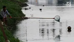 Seorang anak mengambil bola di kali saat kompetisi sepak bola di pinggir Kali Banjir Kanal Barat, Jakarta, Sabtu (5/11). Minimnya sarana bermain sepak bola mengakibatkan warga terpaksa memanfaatkan lahan di pinggir kali. (Liputan6.com/Johan Tallo)