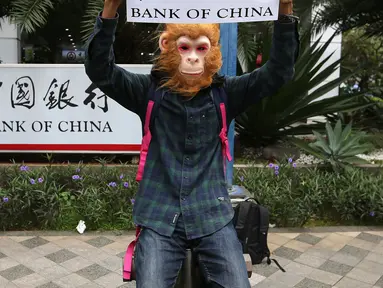 Aktivis WALHI memakai topeng orangutan saat menggelar aksi di depan Gedung Bank of China, Jakarta, Jumat (1/3). Aksi ini digelar jelang putusan PTUN Medan terkait gugatan WALHI terhadap izin lingkungan PLTA Batang Toru. (Liputan6.com/Fery Pradolo)