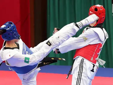 Atlet taekwondo putri Makau, Liu Qing melayangkan tendangannya ke arah Fitriyana Yusuf dari Indonesia pada babak 16 besar di Jakarta Convention Center (JCC), Senin (20/8). Fitriyana kalah tipis 21 - 25 pada kelas Wanita 67 kg. (Liputan6.com/Fery Pradolo)