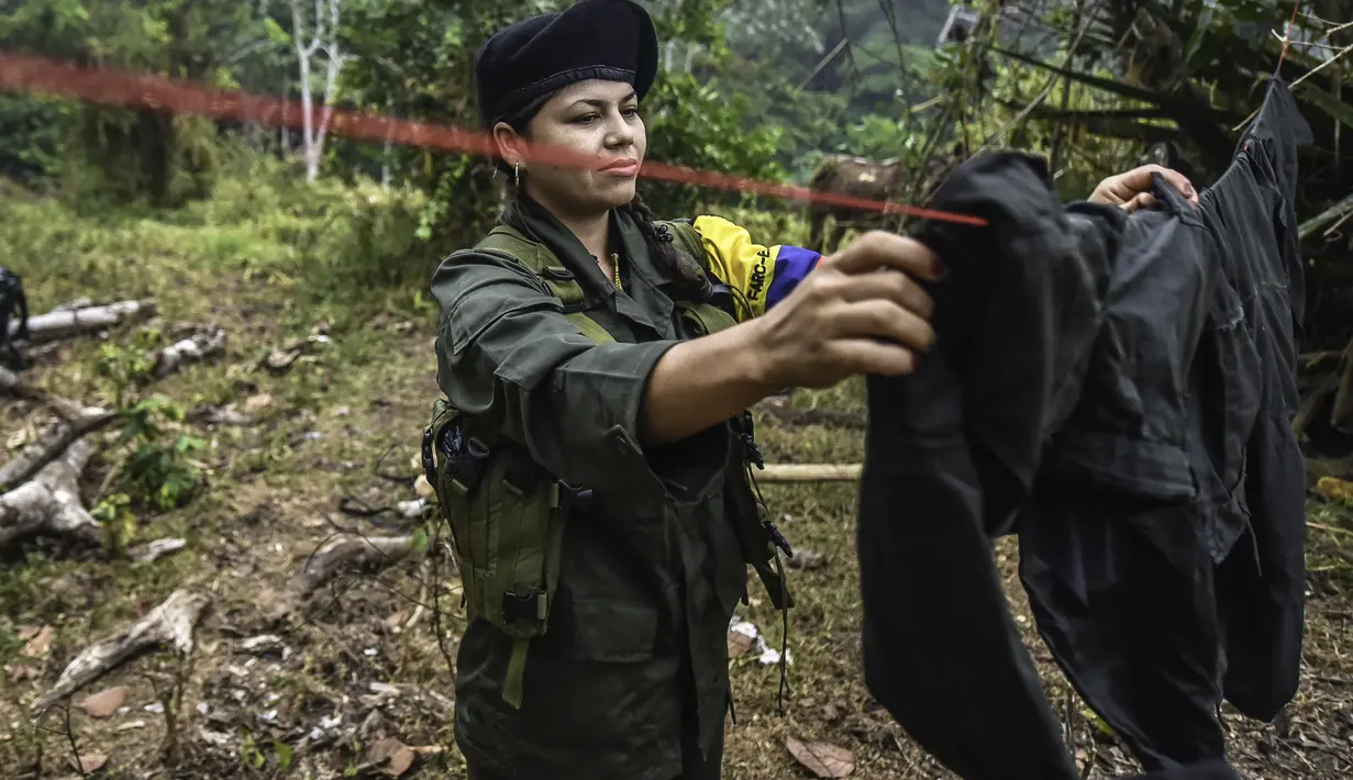 Seorang gerilyawati Pasukan Bersenjata Revolusioner Kolombia (FARC) menjemur pakaian di kamp Magdalena Medio, Kolombia (15/3/2016). Gerilyawati FARC dikenal lebih sadis terhadap musuh daripada pasukan gerilyawan. (AFP Photo/Luis Acosta)