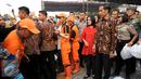 Presiden RI Joko Widodo besertaibu Iriana melihat langsung proses pembagian paket sembako kepada warga di sekitar Lapangan Bedeng, Pisangan Baru, Jakarta, Selasa (8/9/2015). (Liputan6.com/Helmi Fithriansyah)