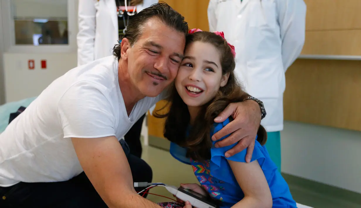 Antonio Banderas memeluk pasien anak di Rumah Sakit Anak-anak Nicklaus di Miami, Florida, AS, Selasa (30/5). Antonio kini aktif di Fundación Lágrimas y Favores, sebuah organisasi yang bergerak di bidang sosial. (AP/David Santiago / El Nuevo Herald)