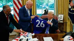 Presiden FIFA, Gianni Infantino memberikan jersey kepada Presiden AS Donald Trump selama pertemuan di Oval Office Gedung Putih, Selasa (28/8). Presiden FIFA bertemu Trump untuk membahas kesiapan Piala Dunia 2026. (AP/Evan Vucci)