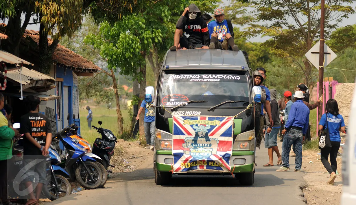 Beberapa suporter naik di atas kendaraan yang menuju Stadion Si Jalak Harupat, Bandung, Minggu (9/6/2015). Kedatangan suporter untuk menyaksikan laga Persib melawan Persebaya Utd di lanjutan Grup A Piala Presiden 2015. (Liputan6.com/Helmi Fithriansyah) 