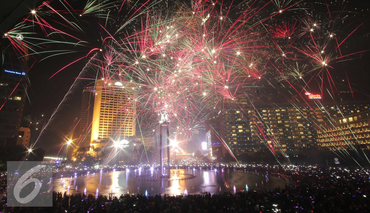 Kembang api menghiasi langit di kawasan Bundaran HI, Jakarta, Jumat (1/1/2016) malam. Kemeriahan kembang api tersebut merupakan bentuk perayaan pergantian tahun 2015 menuju 2016. (Liputan6.com/Angga Yuniar)