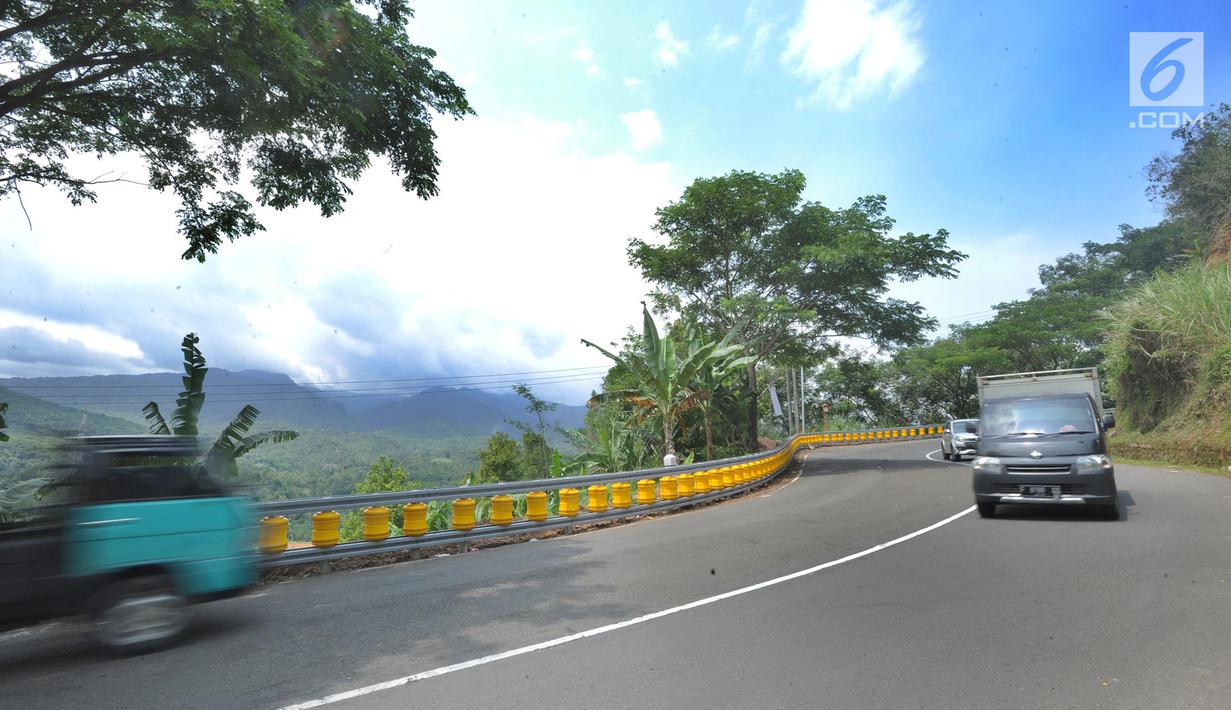 Kendaraan melintas dekat teknologi roller barrier di tanjakan letter S Kampung Bantarselang, Kecamatan Cikidang, Sukabumi, Minggu (6/1). Roller barrier ini diklaim lebih efektif daripada pembatas beton atau besi yang memanjang. (Merdeka.com/Arie Basuki)