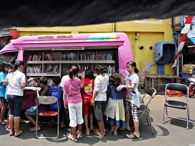 Anak-anak membaca buku yang disediakan perpustakaan keliling di kawasan Tanah Abang, Jakarta, Minggu (11/10). Keberadaan perpustakaan keliling untuk meningkatkan minat baca pada anak-anak. (Liputan6.com/Immanuel Antonius)
