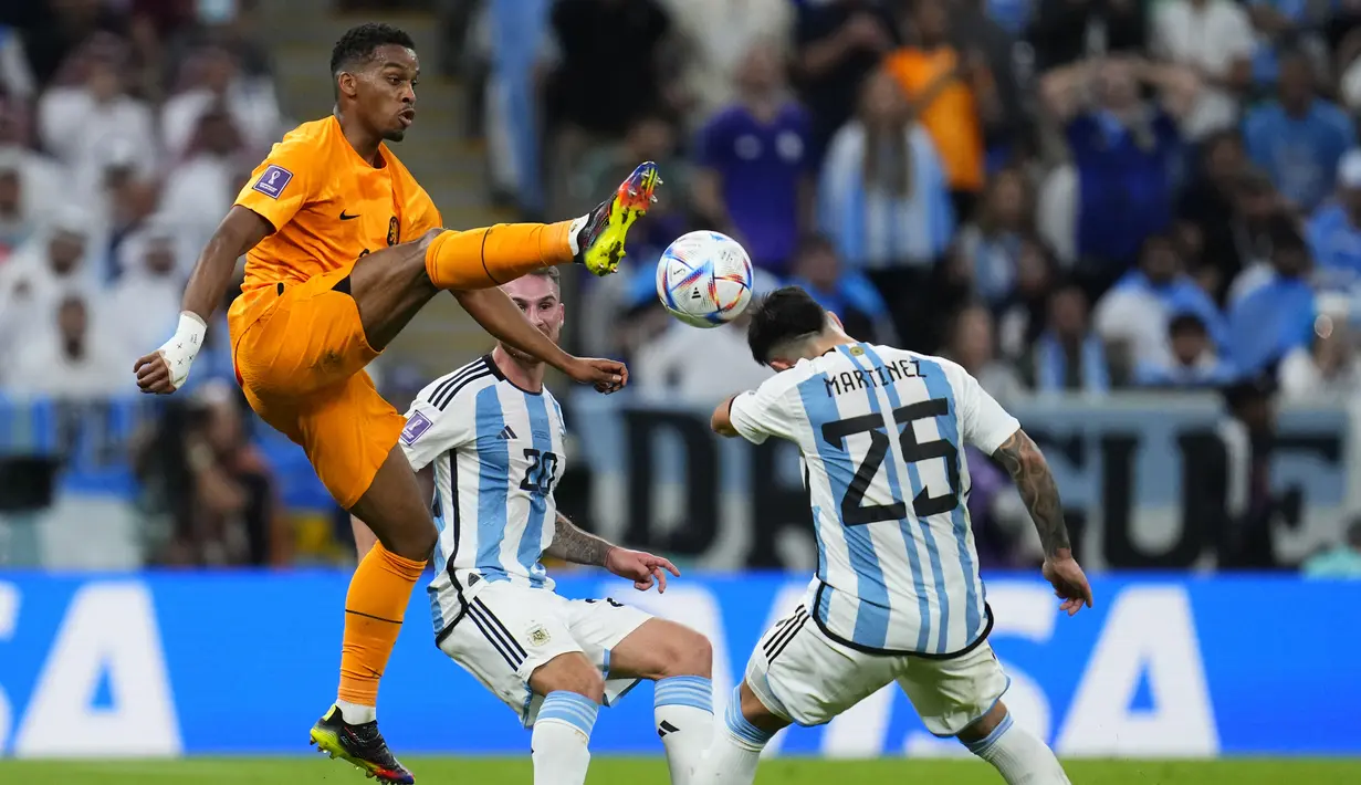 Bek Argentina Lisandro Martinez (kanan) ditantang oleh bek Belanda Jurrien Timber pada babak perempat final Piala Dunia 2022 di Lusail Iconic Stadium, Sabtu (10/12/2022) dinihari WIB. Argentina harus melalui drama adu penalti saat menghadapi Belanda.  (AP Photo/Natacha Pisarenko)