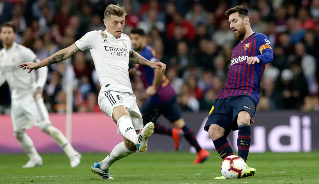 Gelandang Real Madrid, Toni Kroos berusaha merebut bola yang dibawa Striker Barcelona, Lionel Messi selama pertandingan lanjutan La Liga Spanyol di Santiago Bernabeu, Madrid (2/3). Barcelona menang tipis atas Real Madrid 1-0. (AP Photo/Andrea Comas)