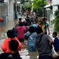Warga melewati banjir yang menggenangi kawasan Kampung Pulo, Jakarta, Kamis (2/1/2020). Hujan yang terjadi kemarin malam membuat Kali Ciliwung meluap ke jalan. (merdeka.com/Imam Buhori)