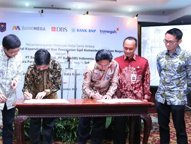 Mendagri Tjahjo Kumolo menyaksikkan (kiri) penandatangan perjanjian kerja sama pemanfaatan no induk kependudukan, data kependudukan dan E KTP di Jakarta, Selasa (20/9). (Liputan6.com/Angga Yuniar)