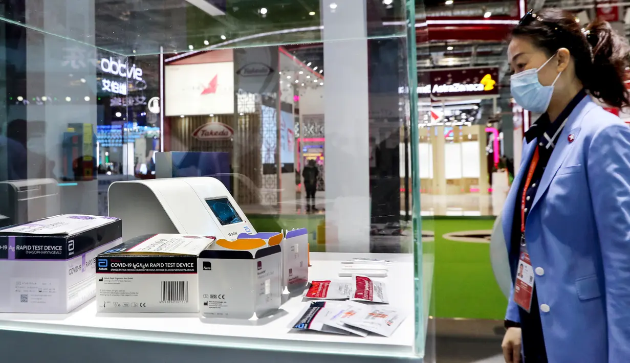 Seorang pengunjung melihat alat tes cepat COVID-19 yang dipamerkan oleh Abbott Laboratories di area khusus untuk kesehatan masyarakat dan pencegahan epidemi dalam gelaran Pameran Impor Internasional China (CIIE) ketiga di Shanghai pada 5 November 2020. (Xinhua/Liu Ying)