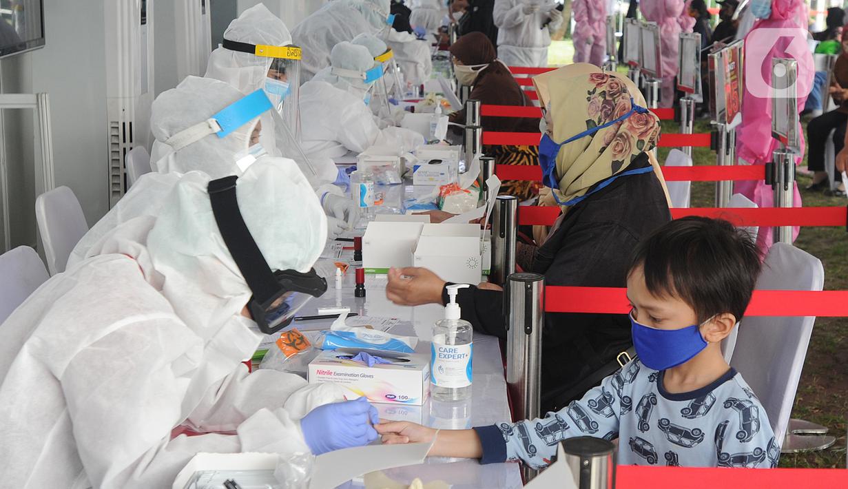 Petugas medis memeriksa seorang anak saat rapid test oleh BIN di Lapangan Kantor Kecamatan Pamulang, Tangerang Selatan, Banten, Kamis (2/7/2020). BIN menggelar rapid test gratis terhadap 800 warga Pamulang untuk memutus mata rantai penyebaran virus corona COVID-19. (merdeka.com/Arie Basuki)