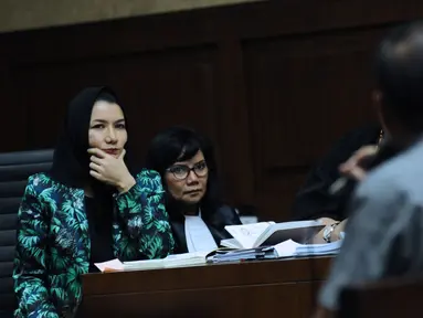 Bupati nonaktif Kutai Kartanegara, Rita Widyasari (kiri) menyimak keterangan saksi pada sidang lanjutan dugaan suap pemberian izin lokasi perkebunan kelapa sawit di Pengadilan Tipikor, Jakarta, Rabu (14/3).(Liputan6.com/Helmi Fithriansyah)