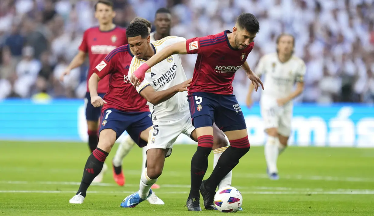 Pemain Real Madrid, Jude Bellingham, berusaha merebut bola dengan pemain Osasuna, David Garcia, pada laga pekan ke-9 La Liga 2023/2024 di Stadion Santiago Bernabeu, Sabtu, (7/10/2023). (AP Photo/Jose Breton)