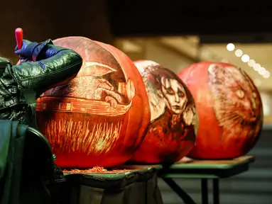 Seorang seniman mengukir labu dalam acara Malam 1.000 Jack-O'-Lantern di Chicago Botanic Garden, Glencoe, Illinois, Amerika Serikat, 24 Oktober 2020. Lebih dari 1.000 labu ukiran tangan dipamerkan di acara tersebut menjelang perayaan Halloween. (Xinhua/Joel Lerner)