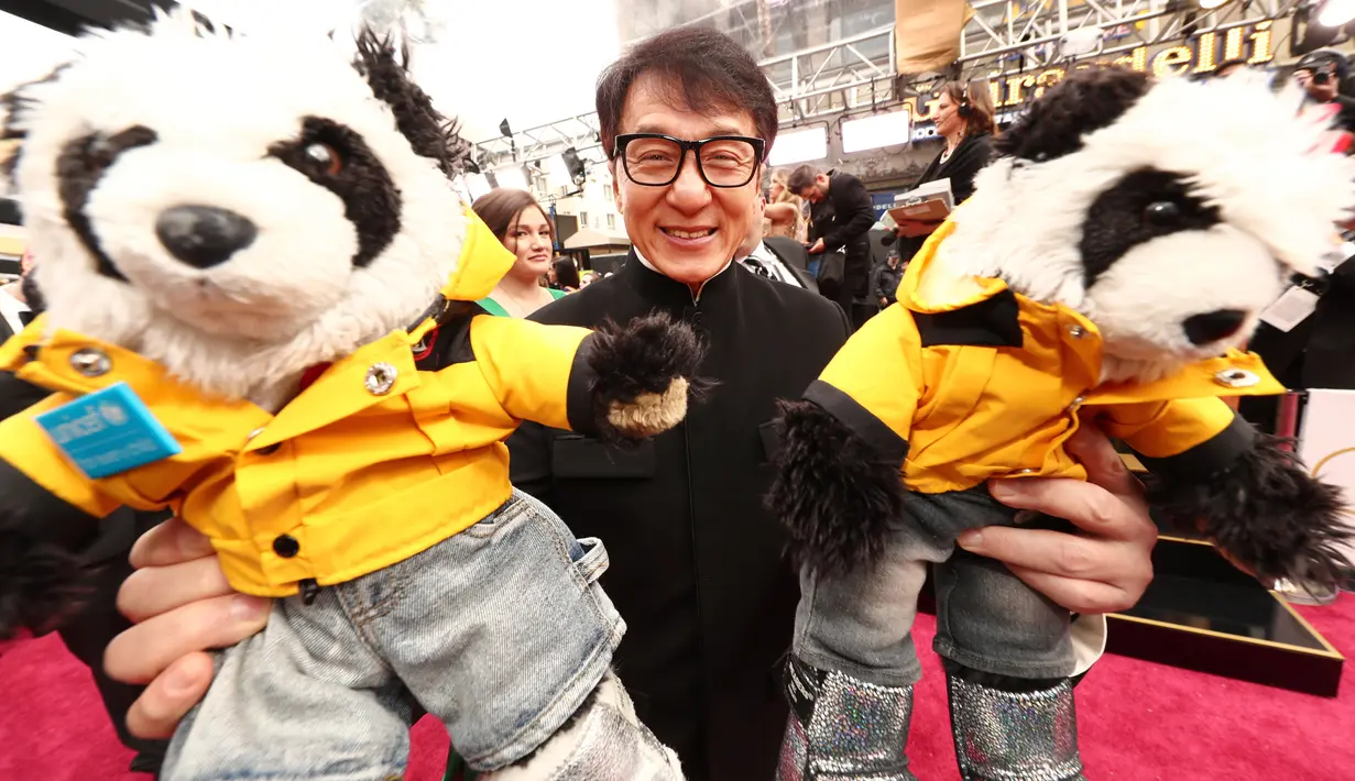 Aktor Jackie Chan setibanya di karpet merah Academy Awards ke-89 di Dolby Theatre, Los Angeles, Minggu (26/2). Menghadiri perhelatan Piala Oscar 2017, Jackie Chan membawa dua boneka panda berjaket kuning. (Christopher Polk/Getty Images/AFP)