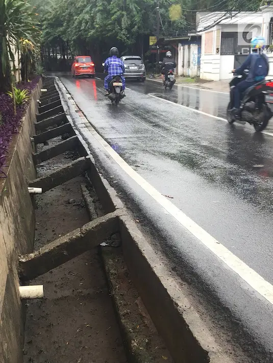 Pengendara melintas di samping selokan tanpa penutup di Jalan Mohammad Kahfi I, Jagakarsa, Jakarta, Selasa (22/1). Selain membahayakan pejalan kaki, kondisi tersebut juga berbahaya bagi pengendara terutama saat malam hari. (Liputan6.com/Immanuel Antonius)