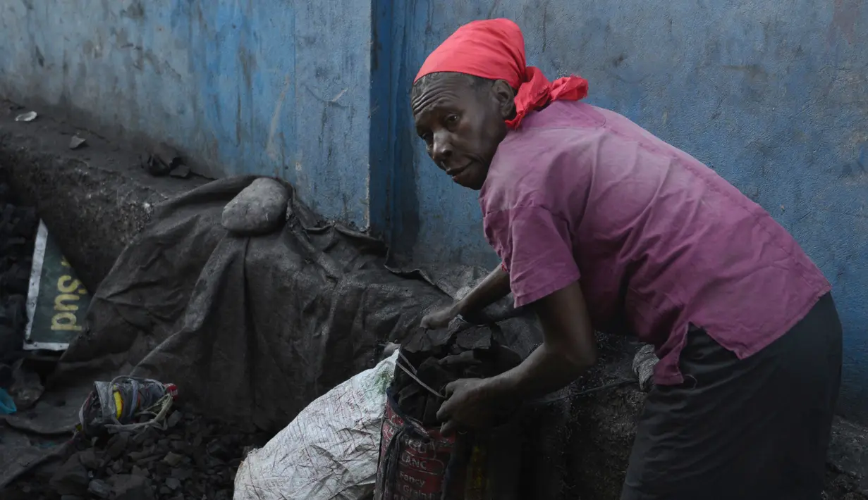 Seorang wanita mengumpulkan arang di depot yang akan dijualnya di pasar lokal, di Les Cayes, Haiti, (25/1). Peraturan tersebut untuk melindungi zona pemotongan kayu. (AP/David McFadden)