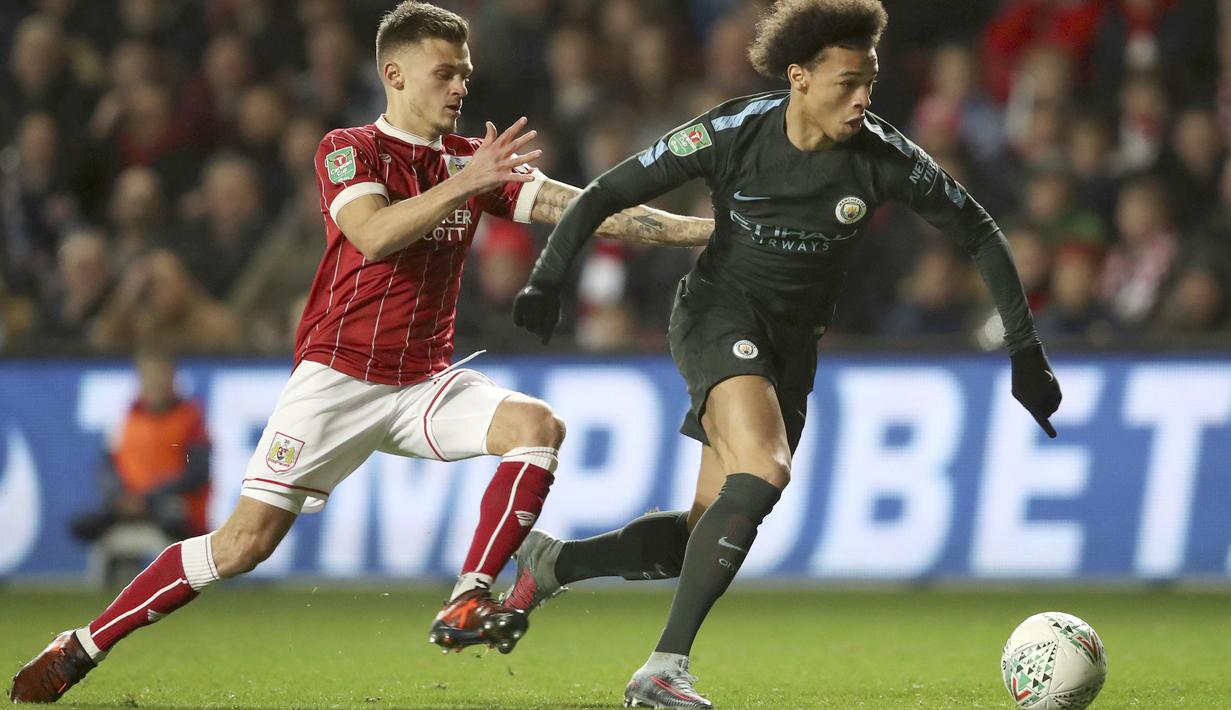 Pemain Bristol City, Jamie Paterson (kiri) berusaha merebut bola dari pemain Manchester City, Leroy Sane pada semifinal Piala Liga Inggris di Ashton Gate stadium, Bristol,(23/1/2018). Manchester City menang 3-2. (Nick Potts/PA via AP)