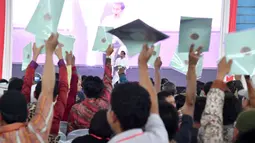 Warga Lampung mengangkat sertifikat yang dibagikan oleh Presiden Jokowi saat kunjungan kerjanya di GOR Way Handak, Kalianda, Lampung Selatan, Minggu (21/1). (Liputan6.com/Pool/Laily Rachev-Biro Pers Setpres)