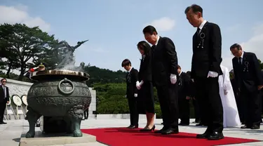 Presiden Korea Selatan Yoon Suk Yeol (tengah) dan istrinya Kim Keon-hee (tengah kiri) memberikan penghormatan dalam upacara peringatan Memorial Day ke-68 di Pemakaman Nasional, Seoul, Korea Selatan, Selasa (6/6/2023). (KIM HONG-JI/POOL/AFP)