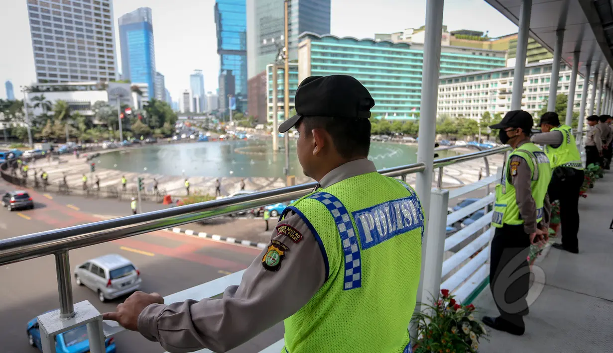 Sejumlah personil kepolisian saat memantau dari atas JPO Bundaran HI dalam gladi lapangan untuk pengamanan peringatan Hari Buruh Internasional atau biasa disebut May Day yang jatuh pada 1 Mei, Jakarta, Jumat (30/4/2015). (Liputan6.com/Faizal Fanani) 