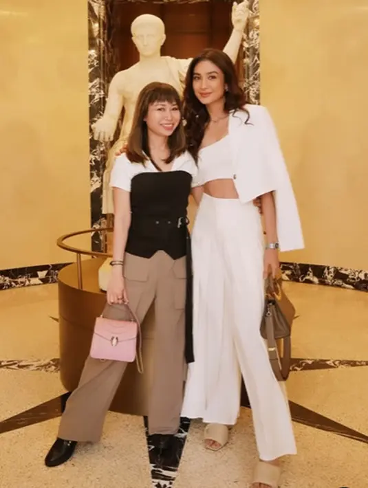 Ia padukan cropped top asimetris dengan palazo ruffle panjang dan cropped blazer putih. [@miktambayong]