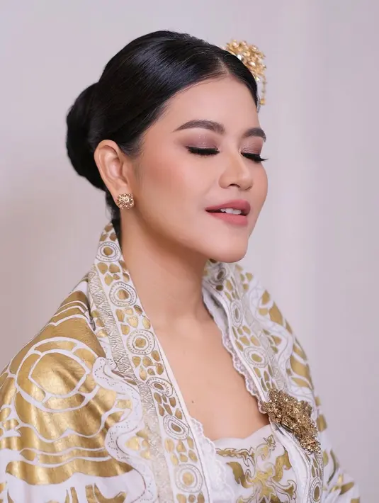 Dress-nya hadir dengan detail kerah square neck dan dihiasi pola bunga keemasan. [@malvava].