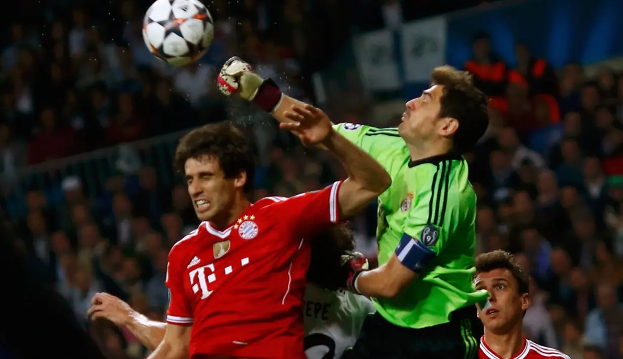 Kiper Real Madrid, Iker Casillas (kanan), berusaha menjauhkan bola dari jangkauan Javi Martinez (Bayern Munich) di laga pertama semifinal Liga Champions di Stadion Santiago Bernabeu, Madrid, Spanyol (24/4/2014). (REUTERS/Michael Dalder)