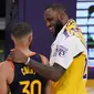 Pebasket Los Angeles Lakers, LeBron James (kanan) merangkul pemain Golden State Warriors, Stephen Curry, setelah berhadapan di play-in-tournament NBA. (AP/Mark J. Terrill).