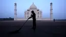 Seorang pria menyapu monumen Taj Mahal di Agra, India, Senin (21/9/2020). Taj Mahal dibuka kembali Senin setelah ditutup selama lebih dari enam bulan karena pandemi virus corona. (AP Photo/Pawan Sharma)