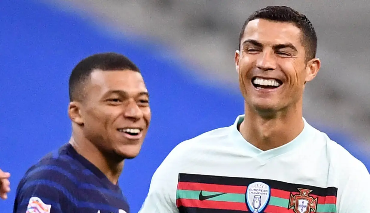 Striker Portugal, Cristiano Ronaldo, tertawa bersama striker Prancis, Kylian Mbappe, pada laga UEFA Nations League di Stadion Stade de France, Senin (12/10/2020). Kedua tim bermain imbang 0-0. (AFP/Franck Fife)