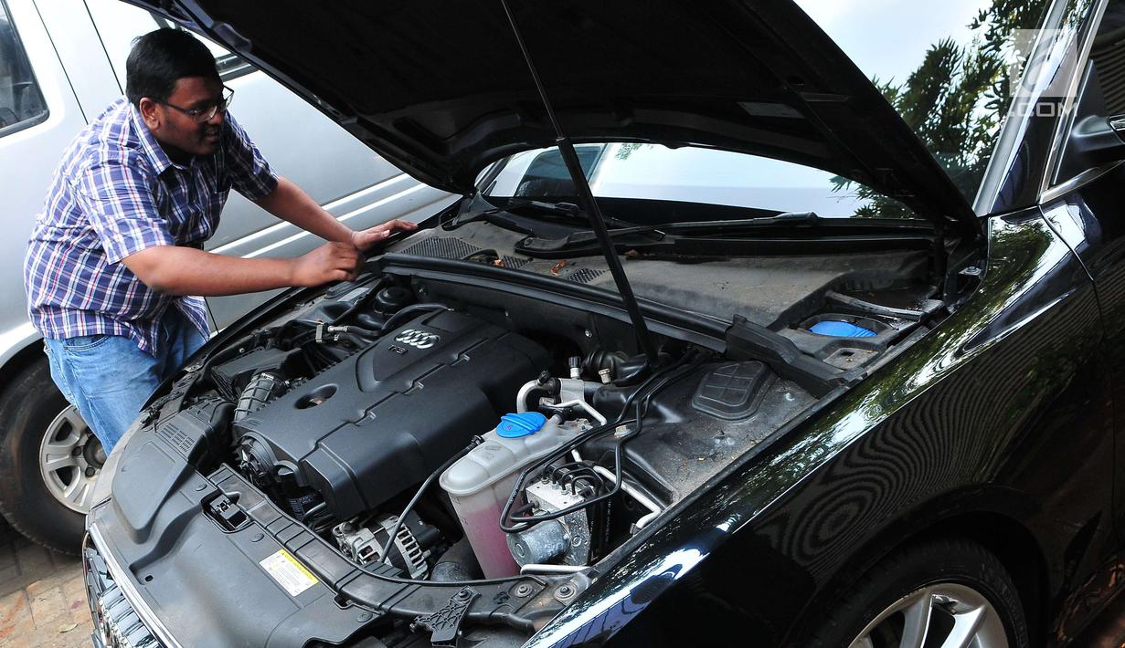 Calon peserta lelang mengecek kondisi mesin mobil hasil sitaan kasus korupsi di Gedung KPK, Jakarta, Selasa (19/9). KPK melelang sebanyak 19 unit mobil dari berbagai model dan merek dengan harga termurah Rp28,8 jutaan. (Liputan6.com/Helmi Afandi)