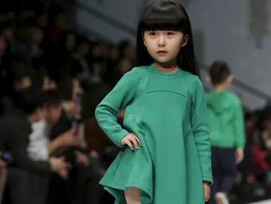  Seorang anak saat membawakan busana koleksi M.latin di Cina Fashion Week S/S 2016 di Beijing, Cina, Rabu (28/10/2015) .  Tingkah lucu anak - anak ini membuat gemas para penonton yang hadir. (REUTERS/Jason Lee)