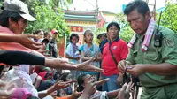 Petugas Vihara Dharma Bakti membagikan angpao dari umat Tionghoa yang datang untuk sembahyang jelang perayaan Imlek, Jakarta, (7/2/2016). Jelang Imlek, ratusan pengemis penuhi Vihara Dharma Bhakti untuk mendapatkan angpao. (Liputan6.com/Yoppy Renato)