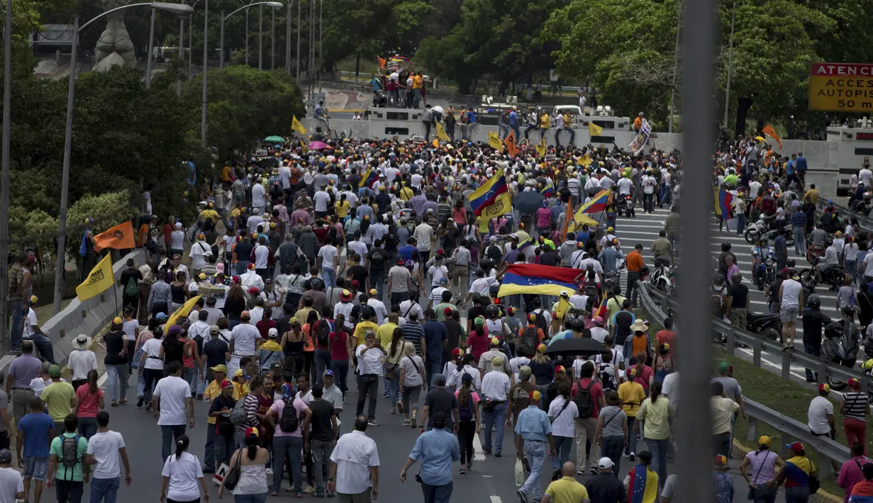 Warga Venezuela turun ke jalan memprotes keputusan Mahkamah Agung  yang mencabut kekuasaan dari Majelis Nasional, di Caracas, Venezuela, Sabtu (1/4). (AP Photo / Fernando Llano)
