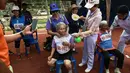 Seorang wanita lansia berusia 80 tahun, Duangpee Sansing (tengah) beristirahat usai memenangkan perlombaan sprint 400 meter dalam Elderly Games Nasional di Thailand (25/4). (AFP/Lillian Suwanrumpha)