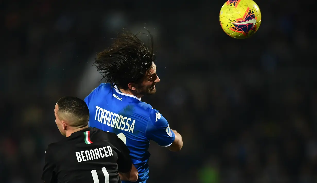 Pemain depan Brescia, Ernesto Torregrossa, berebut bola dengan gelandang  AC Milan, Ismael Bennacer dalam pertandingan lanjutan kompetisi Liga Italia Serie A di Stadion Mario Rigamonti, Jumat (24/1/2020). AC Milan menang 1-0 lewat gol tunggal Ante Rebic. (MIGUEL MEDINA / AFP)
