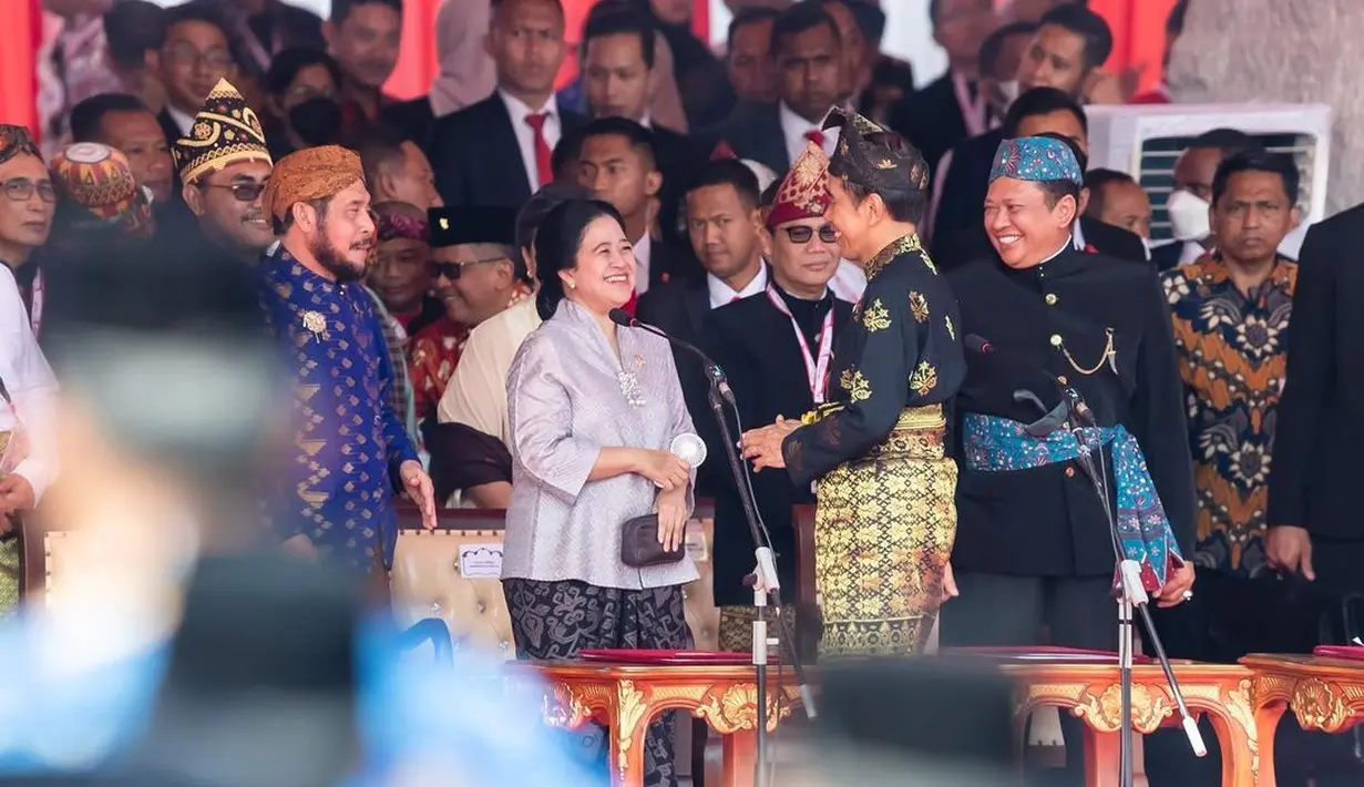 Puan Maharani terlihat cantik elegan mengenakan kebaya abu-abu sedang berbincang dengan Presiden Jokowi. Ia memadukan penampilannya dengan kain batik bernuansa hitam sebagai rok dan detail manis berupa bros silver. [Foto: Instagram/puanmaharaniri]